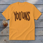 Orange t-shirt with brown "YOU'UNS" text, next to a glass of iced tea.