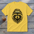 Yellow t-shirt with black and white illustration of a raccoon wearing a beanie with a mountain patch.