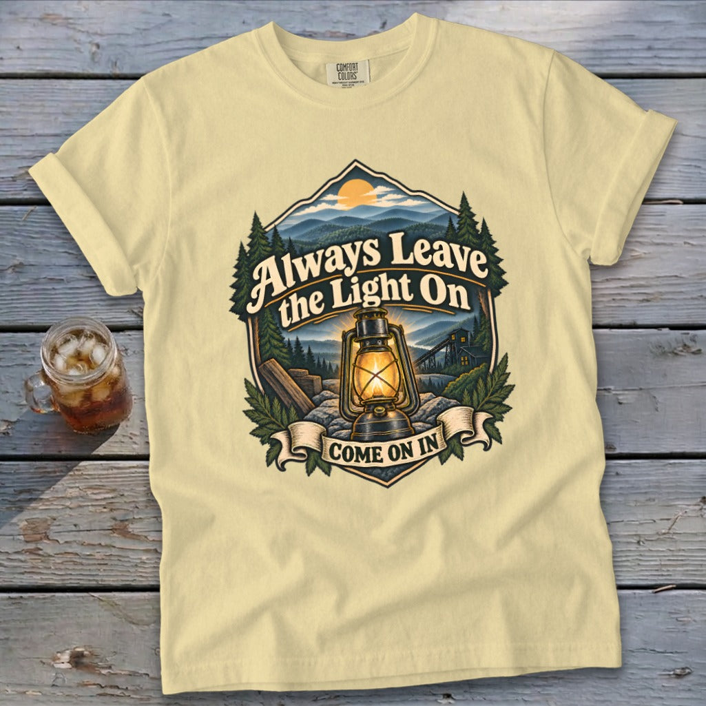 Light yellow t-shirt with "Always Leave the Light On Come On In" text and lantern graphic.
