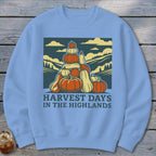 Light blue crewneck sweatshirt featuring a graphic of stacked pumpkins, hills, and the text Harvest Days in the Highlands.