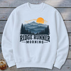 White sweatshirt with mountain and sunrise graphic and text "RIDGE RUNNER MORNING".