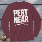 Maroon long-sleeve t-shirt with white text reading PERT NEAR above a mountain range graphic.