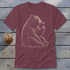 Maroon t-shirt with sketch of bear sitting and blowing on a dandelion