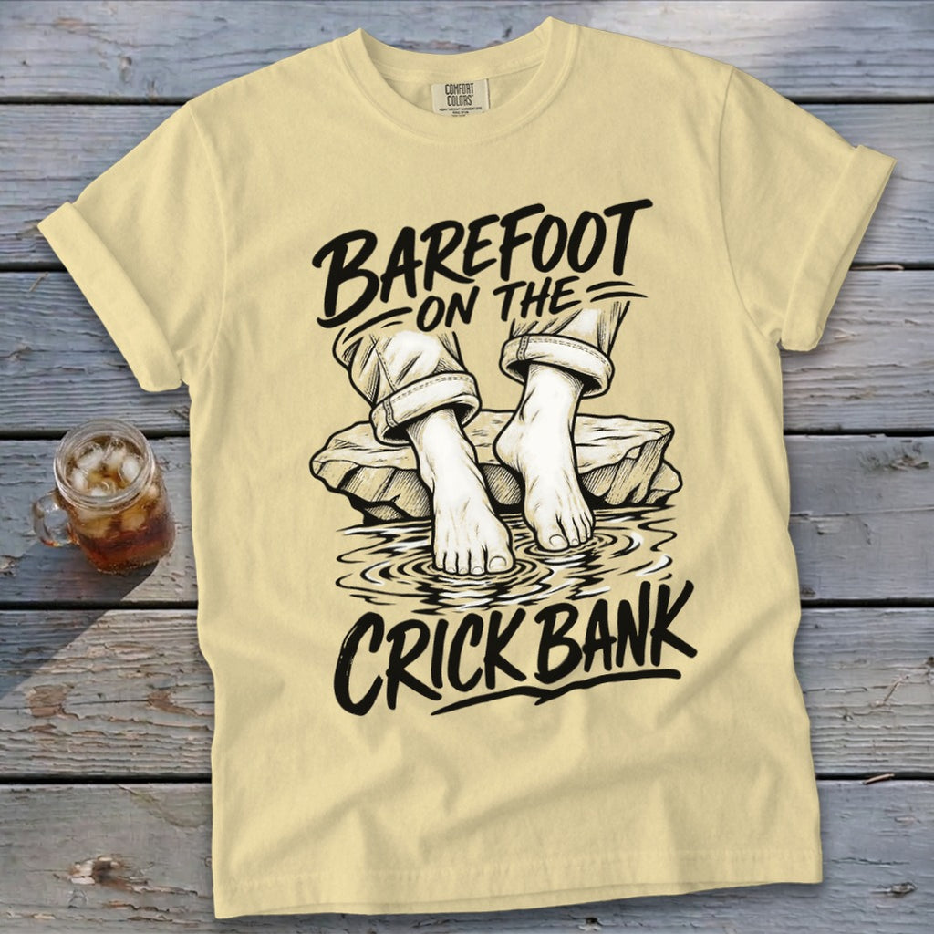 T-shirt graphic with text "Barefoot on the Crick Bank" and drawn feet in water.