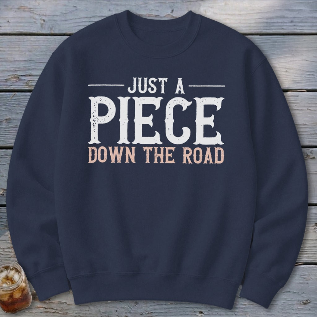 Navy sweatshirt with "JUST A PIECE DOWN THE ROAD" text.