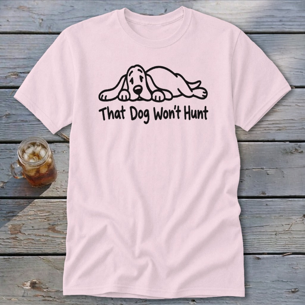 Light pink t-shirt featuring a graphic of a sleeping hound dog and the text That Dog Won't Hunt.