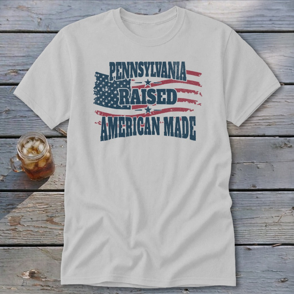 Light gray t-shirt with a distressed graphic of an American flag and text that reads Pennsylvania Raised American Made.