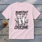 Pink t-shirt with "BAREFOOT ON THE CRICK BANK" text and bare feet graphic.