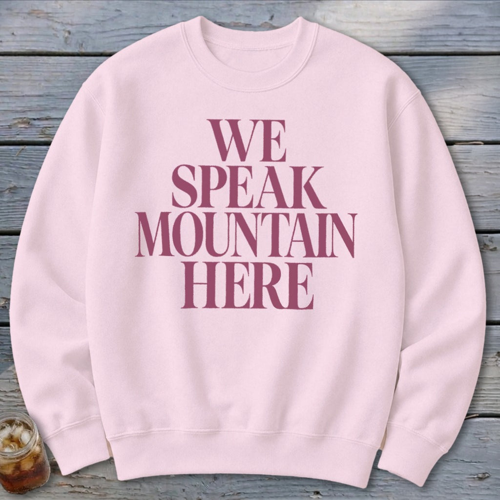 Light pink crewneck sweatshirt with maroon text that reads "WE SPEAK MOUNTAIN HERE".