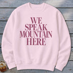 Light pink crewneck sweatshirt with maroon text that reads "WE SPEAK MOUNTAIN HERE".