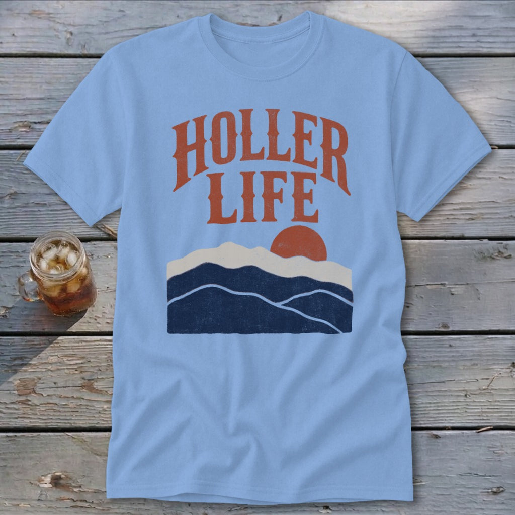 A light blue t-shirt with orange text reading HOLLER LIFE above a sunset mountain graphic.
