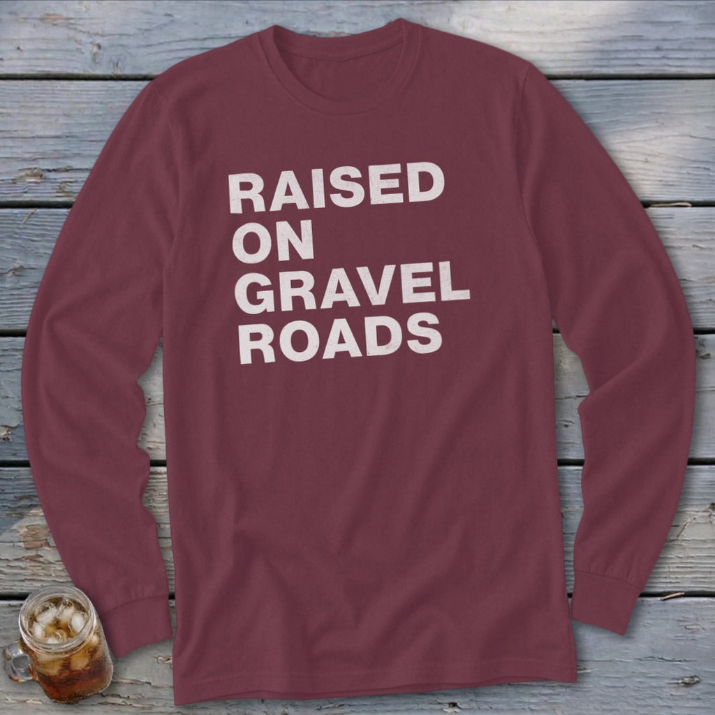 Maroon long-sleeve shirt with "RAISED ON GRAVEL ROADS" text in white.