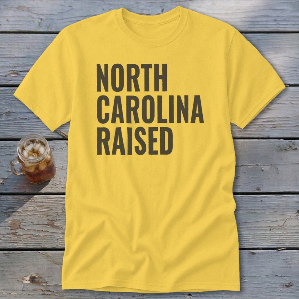 Yellow t-shirt with "NORTH CAROLINA RAISED" in dark gray text.