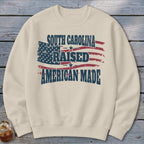 Cream sweatshirt with distressed American flag graphic and text.