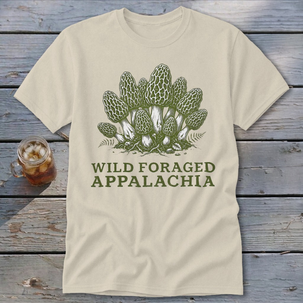 Light-colored t-shirt with a green illustration of morel mushrooms and text "WILD FORAGED APPALACHIA".