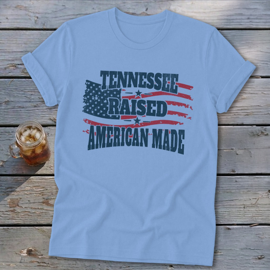 Light blue t-shirt with distressed American flag graphic and text: Tennessee Raised American Made.