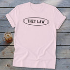 Pink t-shirt with black oval text reading "THEY LAW".
