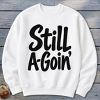 White crewneck sweatshirt with the black text Still A-Goin centered on the chest.