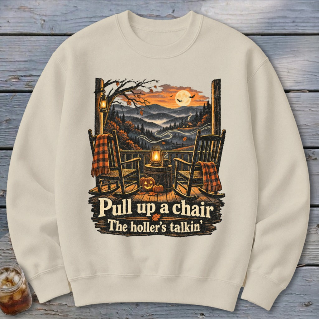 Cream sweatshirt with "Pull up a chair, The holler's talkin'" and autumn porch scene.