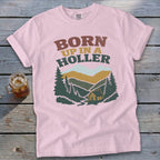 Pink t-shirt with "BORN UP IN A HOLLER" text and mountain landscape graphic.