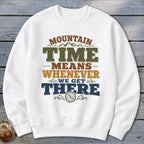 White sweatshirt with "Mountain Time Means Whenever We Get There" graphic and clock.