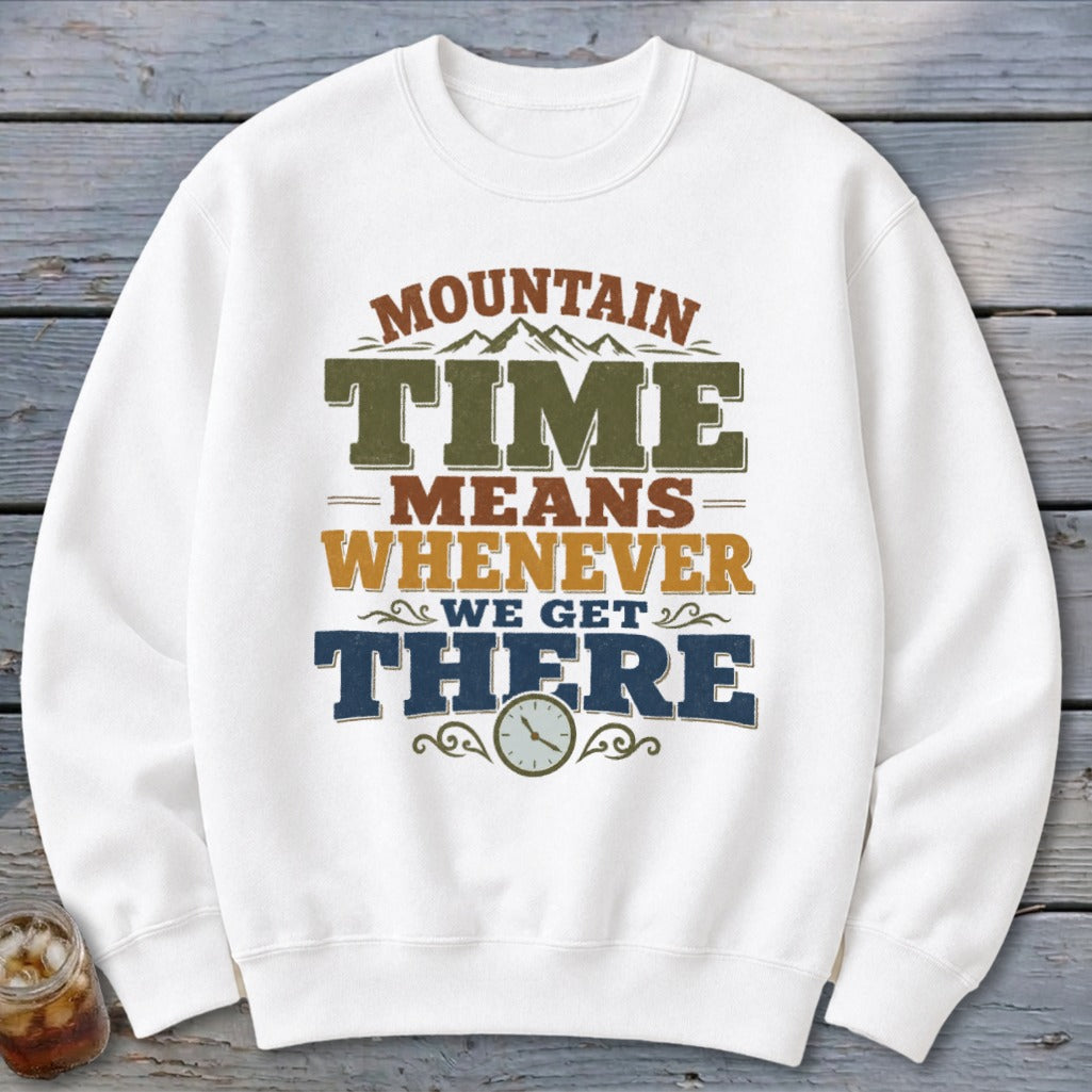 White sweatshirt with "Mountain Time Means Whenever We Get There" graphic and clock.