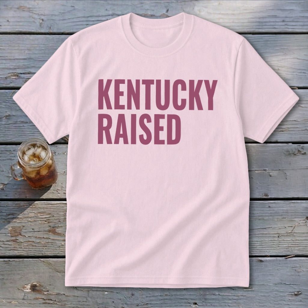 Pink t-shirt with maroon text that reads "KENTUCKY RAISED".