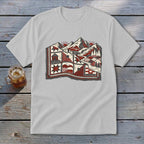 A light grey t-shirt featuring a stylized graphic of a patchwork quilt landscape with mountains, trees, and suns.