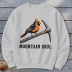 White sweatshirt with graphic of cardinal on pickaxe and text "MOUNTAIN SOUL".