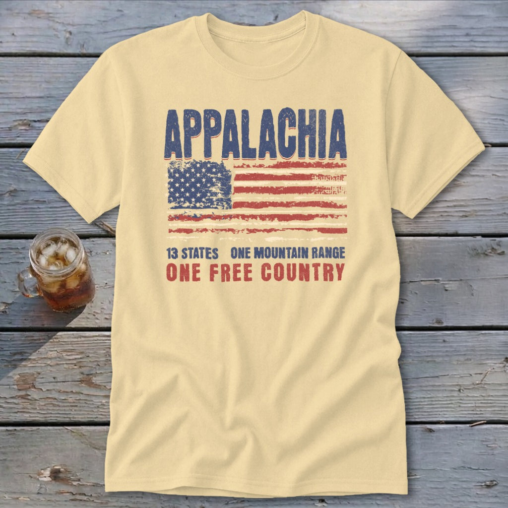 A cream-colored t-shirt featuring a distressed American flag graphic with the text Appalachia, 13 states, one mountain range, one free country.