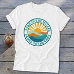 White t-shirt with a round graphic showing mountains, a rising sun, and text.