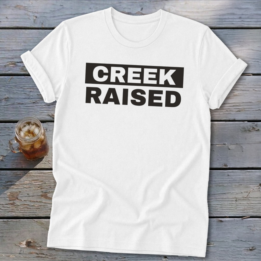 White t-shirt with black text that reads "CREEK RAISED".