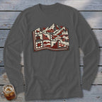 A charcoal grey long-sleeve t-shirt with a red, black, and white graphic of a quilt featuring mountains, suns, trees, and cabins.