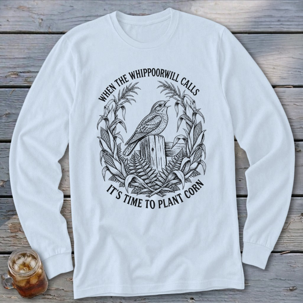 White long-sleeved t-shirt with a vintage black graphic of a bird on a fence and cornstalks.