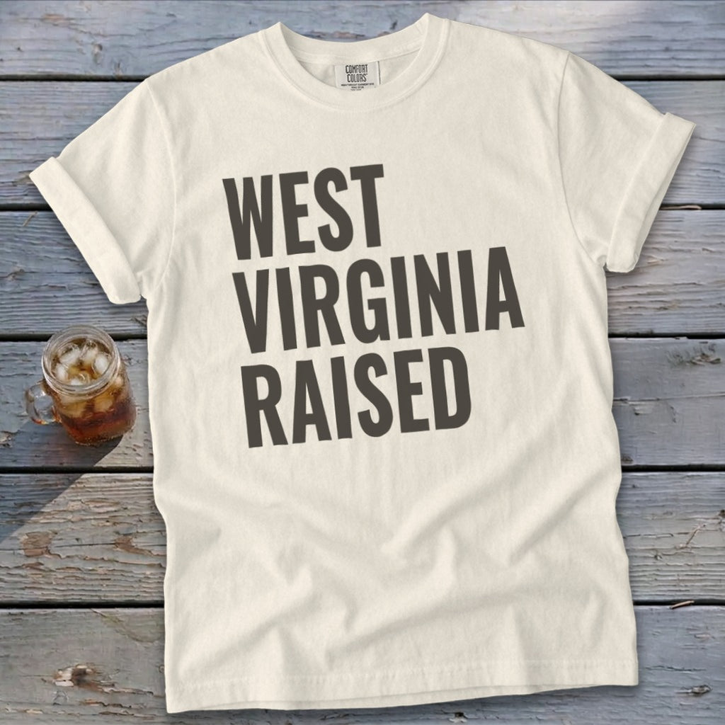 Cream t-shirt with "WEST VIRGINIA RAISED" printed in dark gray.