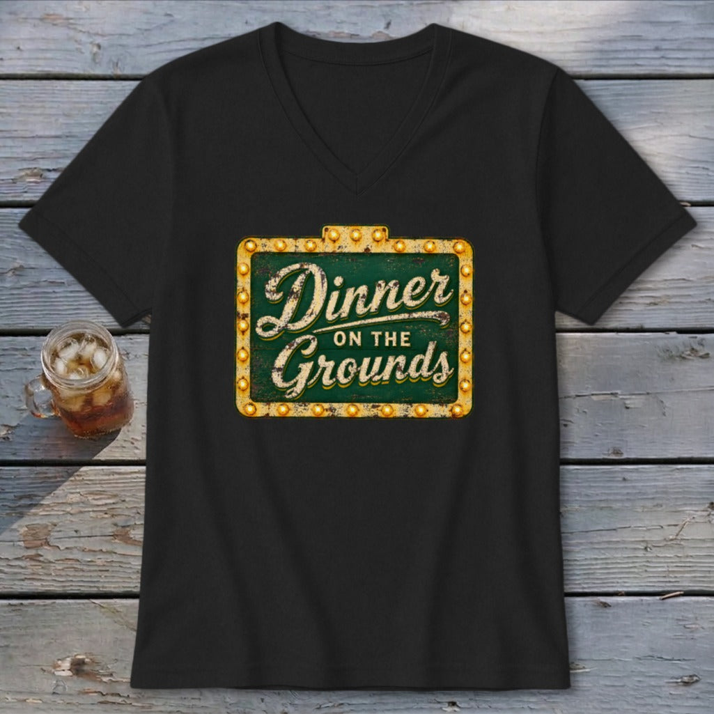 Black v-neck t-shirt featuring a retro marquee graphic that reads Dinner on the Grounds.