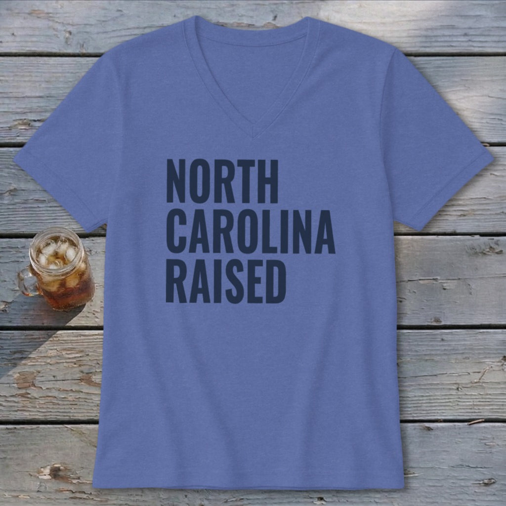 Purple v-neck t-shirt with dark grey text "NORTH CAROLINA RAISED".