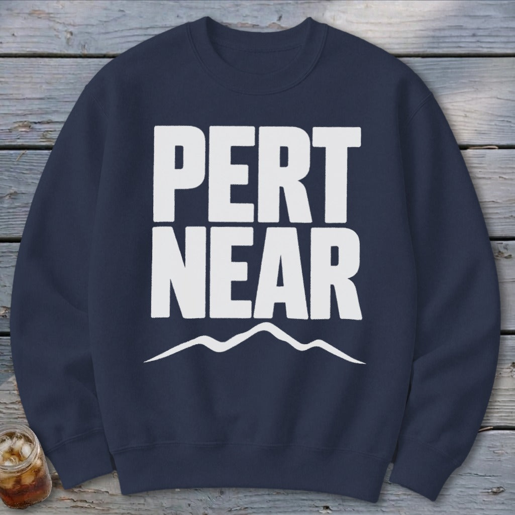 A navy blue crewneck sweatshirt with bold white text reading PERT NEAR above a simple mountain outline.
