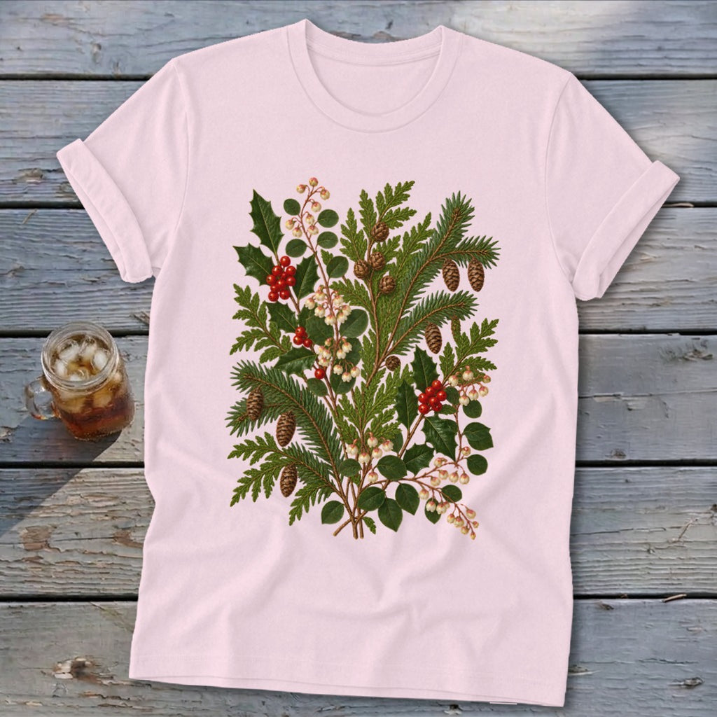 Light pink t-shirt with a green botanical illustration of holly, pine, and pinecones.