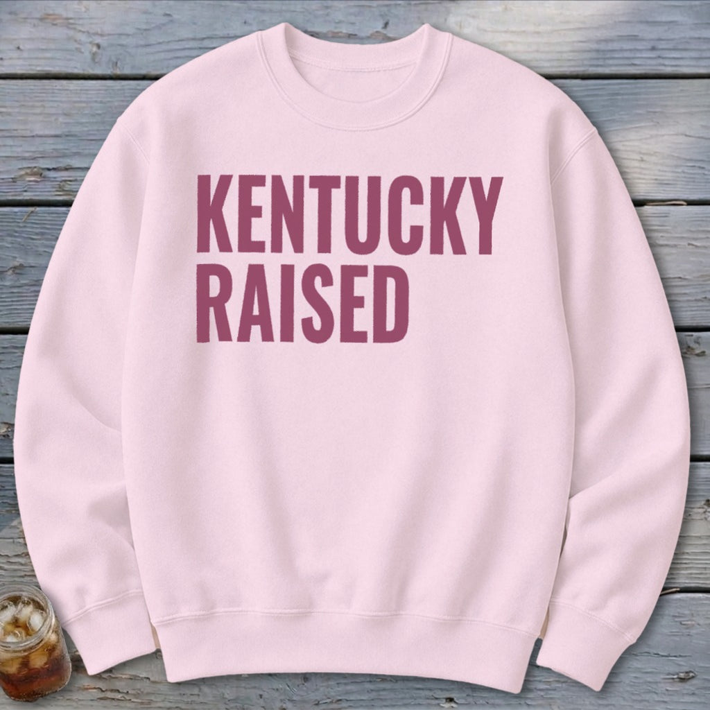 Light pink crewneck sweatshirt with "KENTUCKY RAISED" text in maroon.