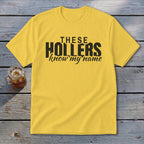Yellow t-shirt with black text "THESE HOLLERS know my name"