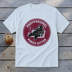 A white short-sleeve t-shirt with a maroon circular graphic of a bear lounging on a porch swing, accompanied by the text "PROFESSIONAL PORCH SITTER".
