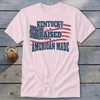 Pink t-shirt with distressed American flag graphic and text "Kentucky Raised American Made".