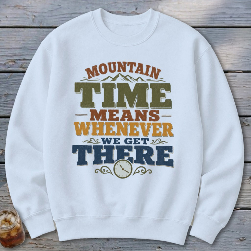 White sweatshirt with "Mountain Time Means Whenever We Get There" text and clock graphic.
