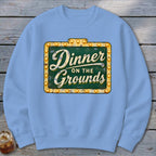 Light blue crewneck sweatshirt featuring a graphic of a lighted sign that reads Dinner on the Grounds.