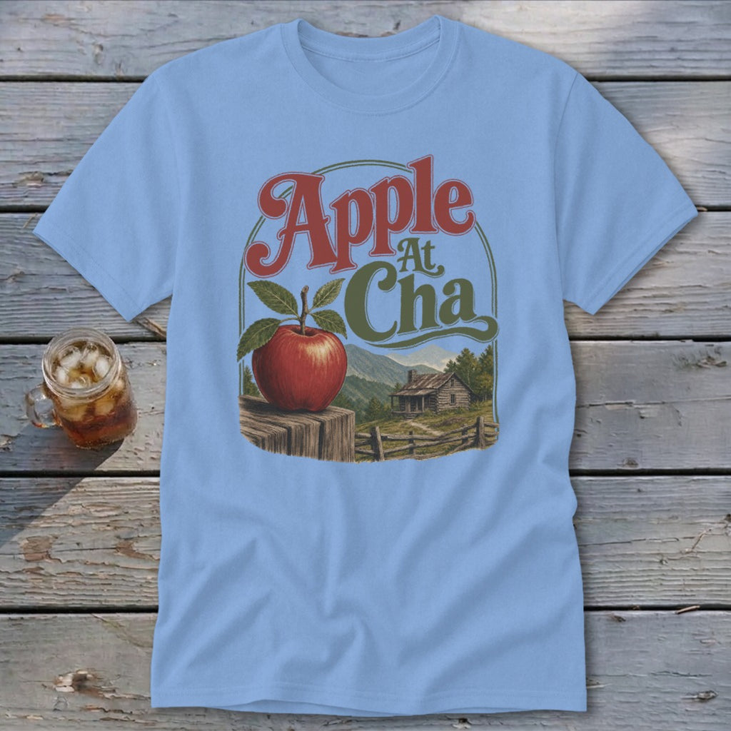 Light blue t-shirt featuring a retro graphic of an apple, a cabin, and mountains with the text Apple At Cha.