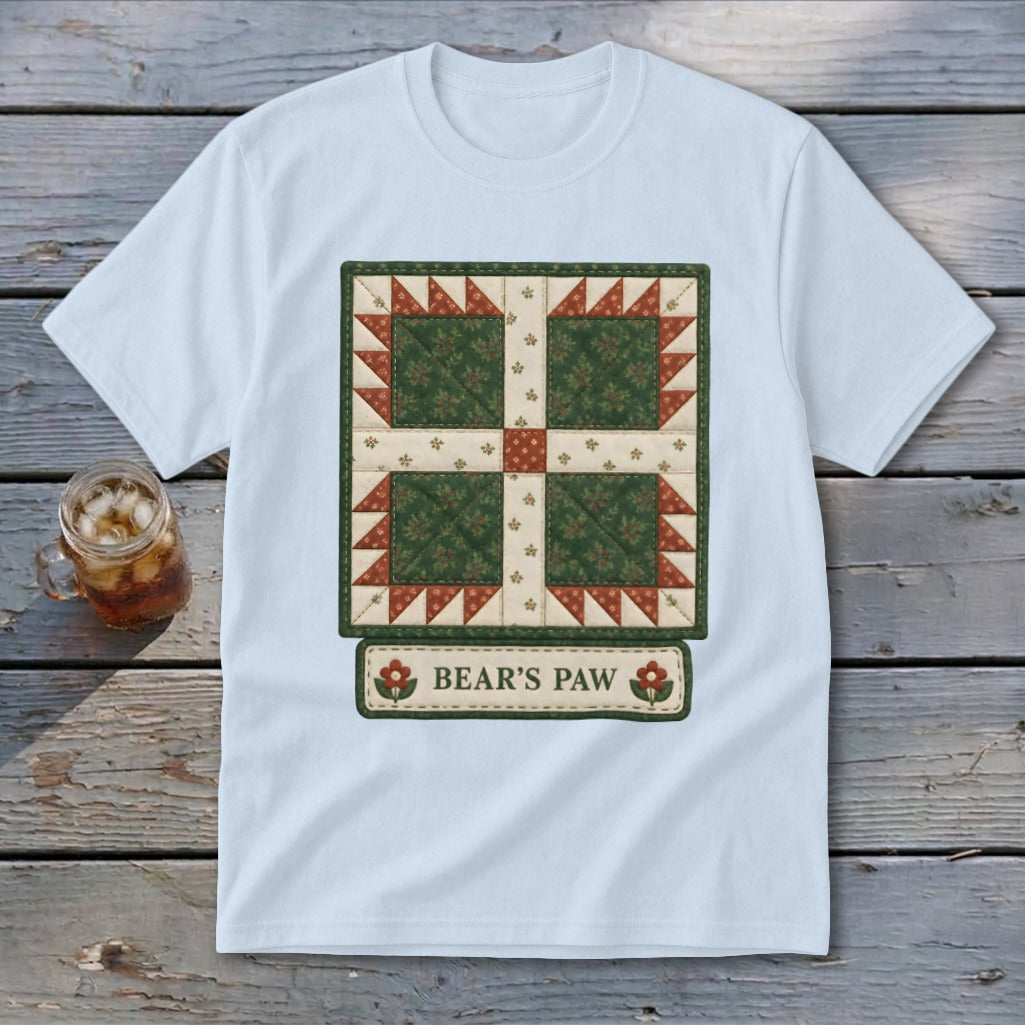 White t-shirt featuring a green and red "Bear's Paw" quilt block design.