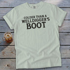 Light blue t-shirt with black text that reads "Colder Than a Welldigger's Boot".
