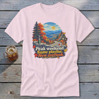 T-shirt with fall mountain scene and text: Peak weekend, Same playlist, New overlook.
