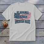 White t-shirt with distressed American flag and text "ALABAMA RAISED AMERICAN MADE".